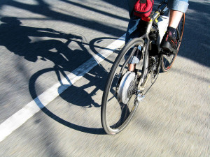 cyclist riding on road with shadow