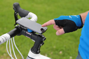 Finger touches smartphone mounted on bike