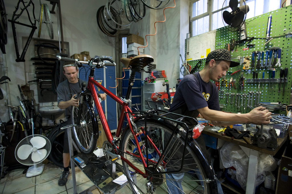 repairs bicycle tools wrenches fan fans red bike cycle cyclists man men work working mechanic mechanics tinker fix saddle handlebars seat wheel wheels spokes crossbar chain sprocket sprockets tools cycles mechanic workshop  vehicle vehicles bicycles work